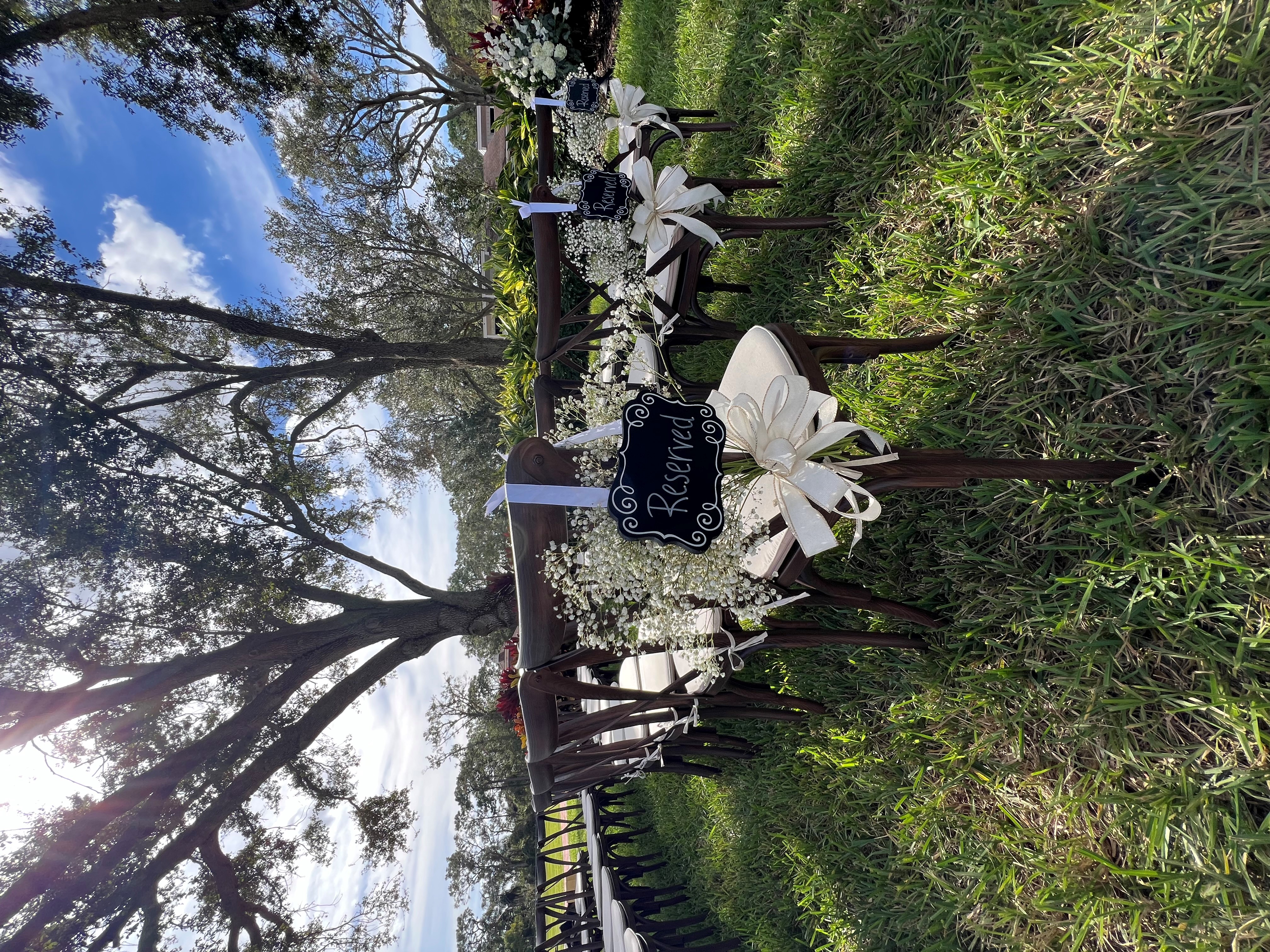 Wedding ceremony with reserved signs and baby's breath on cross back chairs