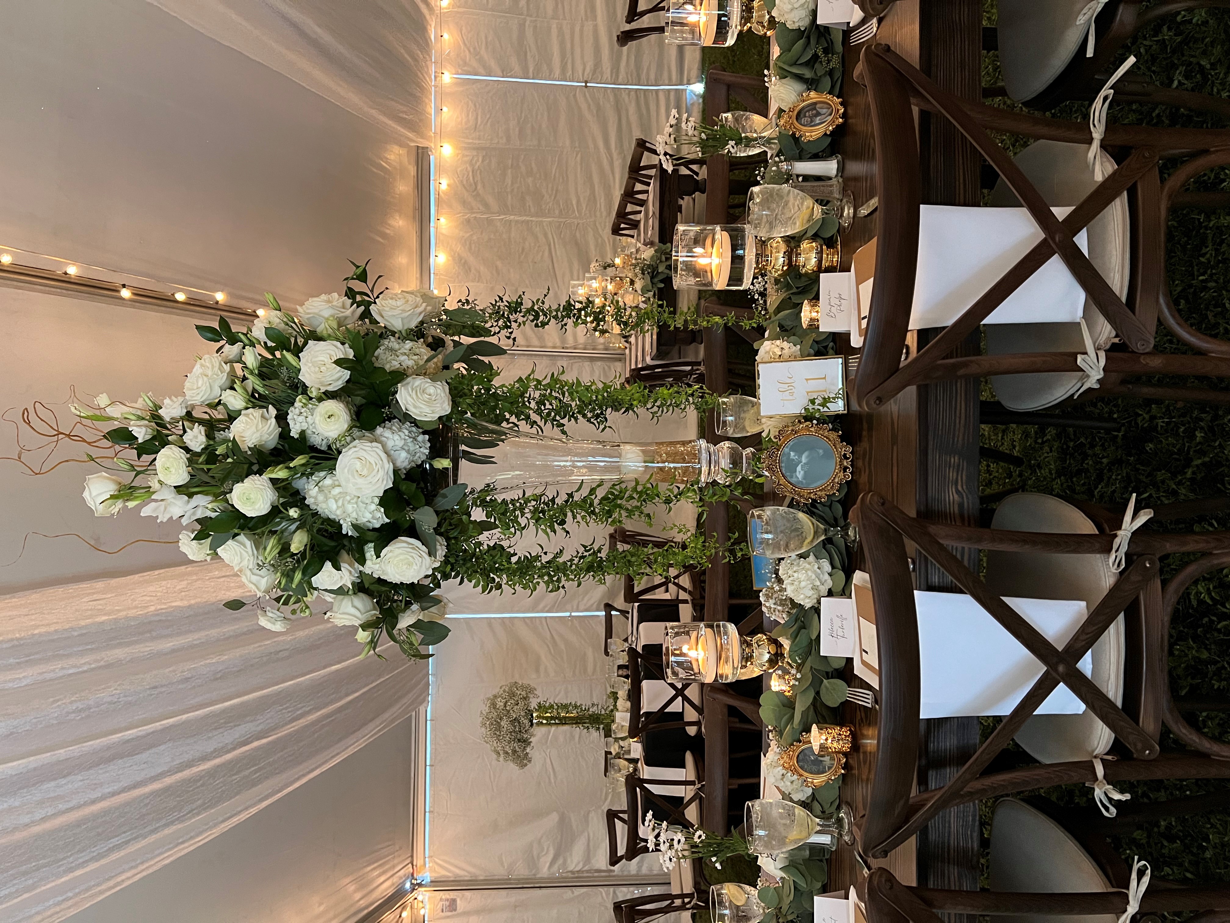 Stunning tall floral wedding centerpiece with white roses and cascading greenery