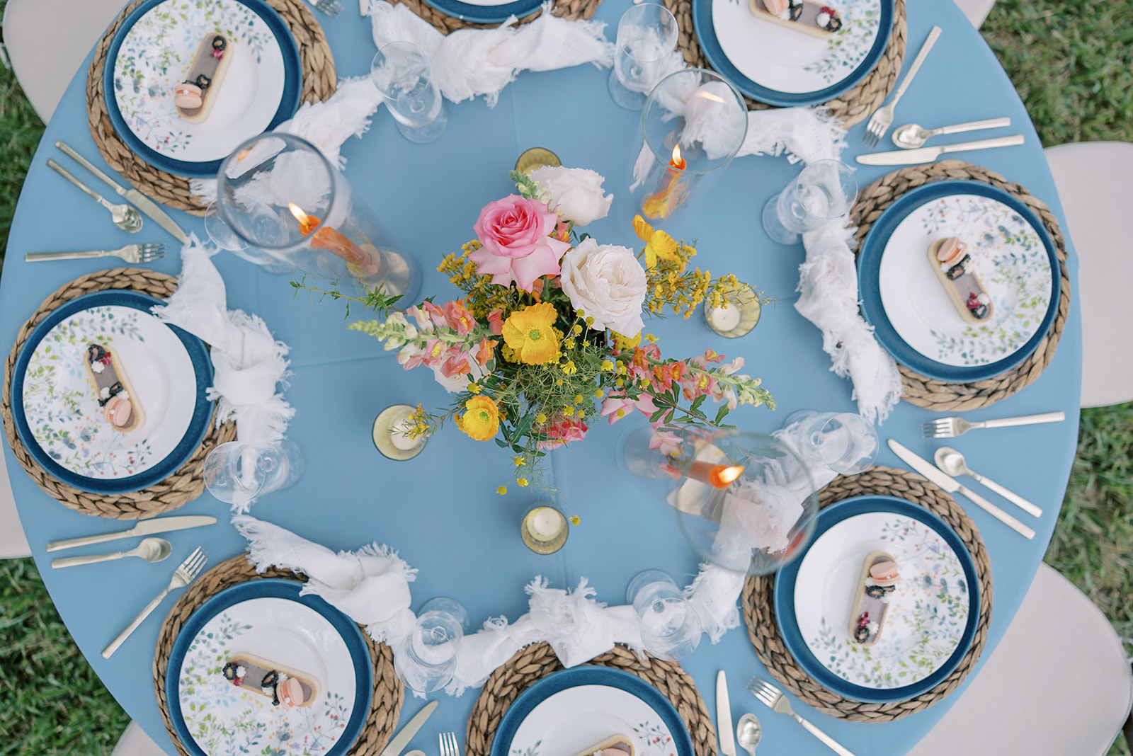Beautiful wedding table setting with blue, orange, pink, yellow details and accents of gold