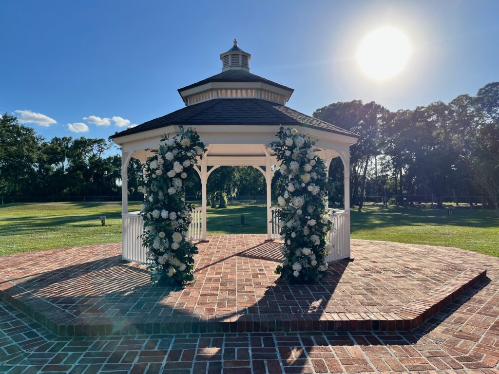 The sweetest white gazebo with floral pillars for wedding ceremony