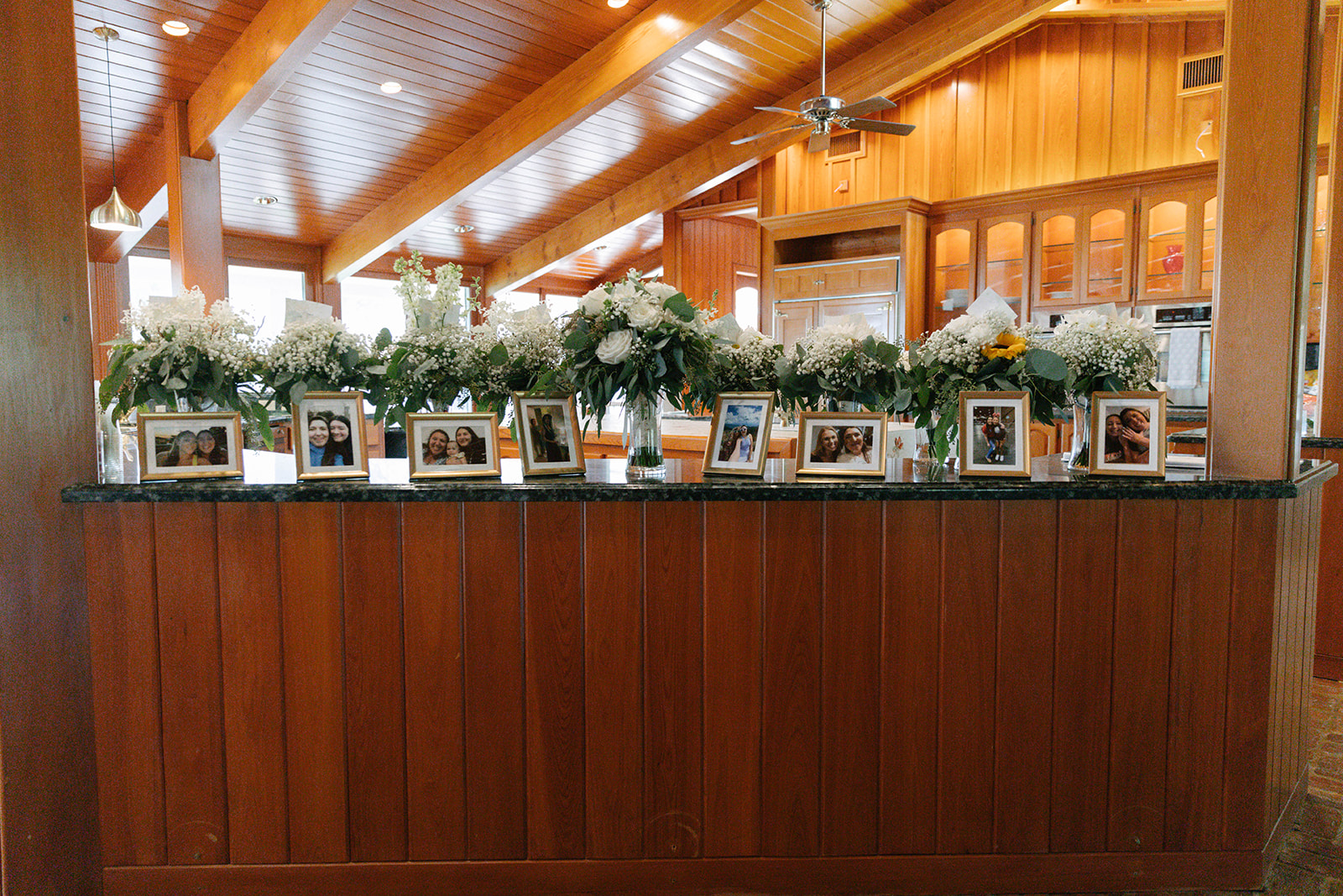 Bridal bouquets spread out on counter with framed photos of each bridesmaid with the bride